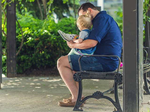 un papa faisant la lecture à son enfant