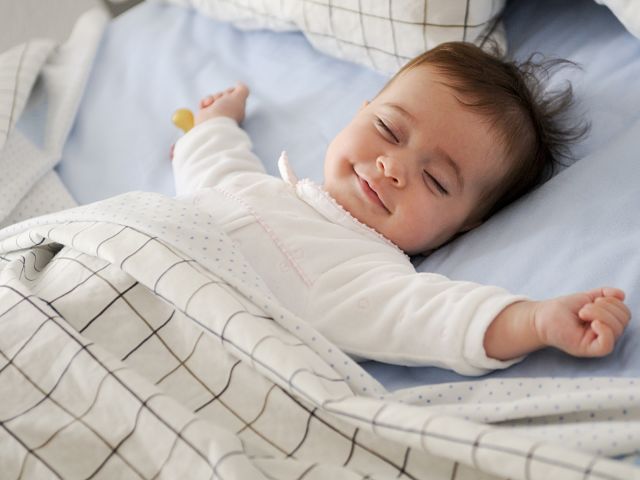un bébé souriant pendant son sommeil