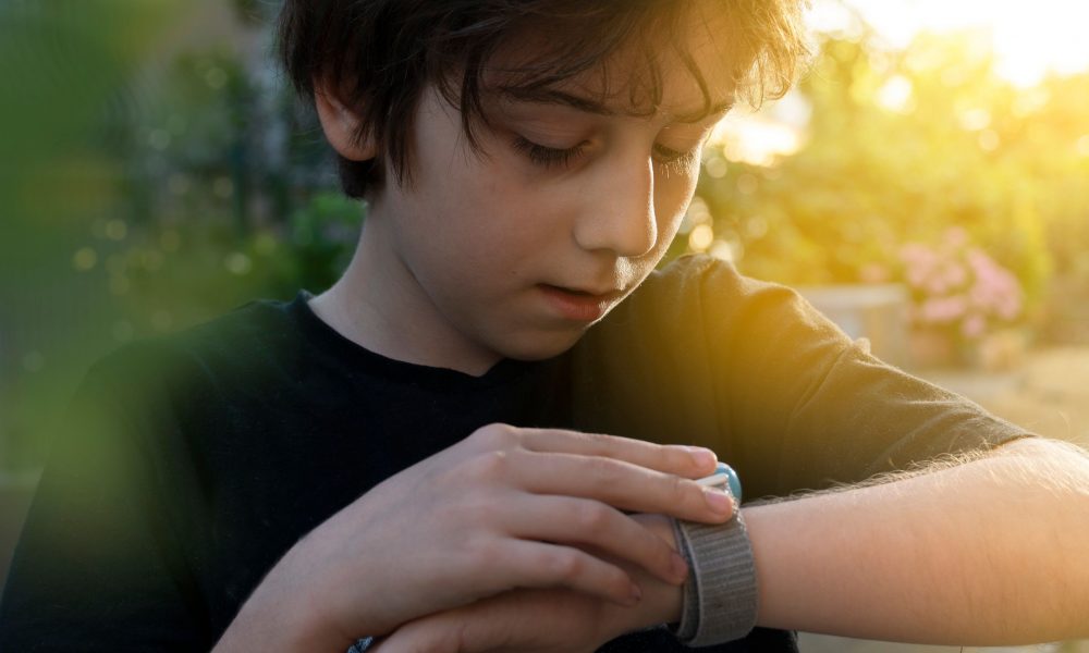 Un enfant consultant sa montre connectée