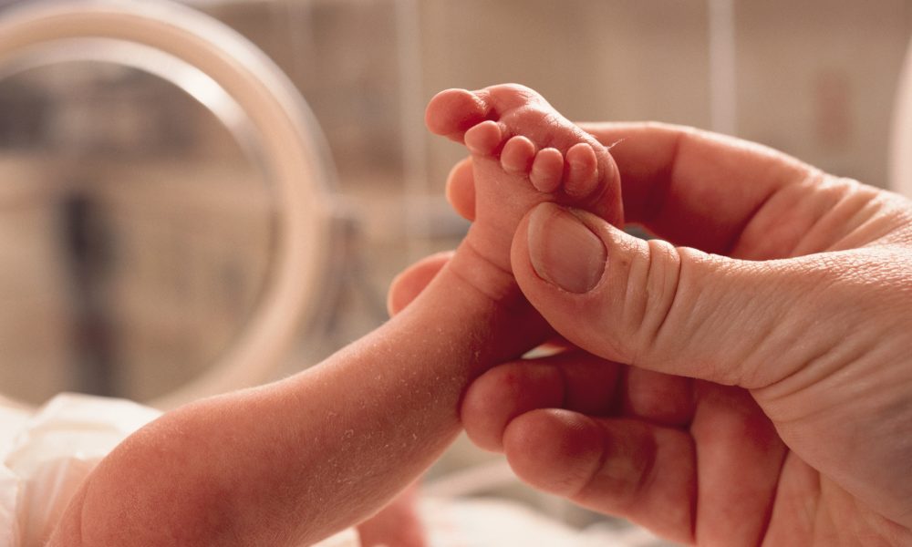 Une main tenant le pied d’un nouveau-né
