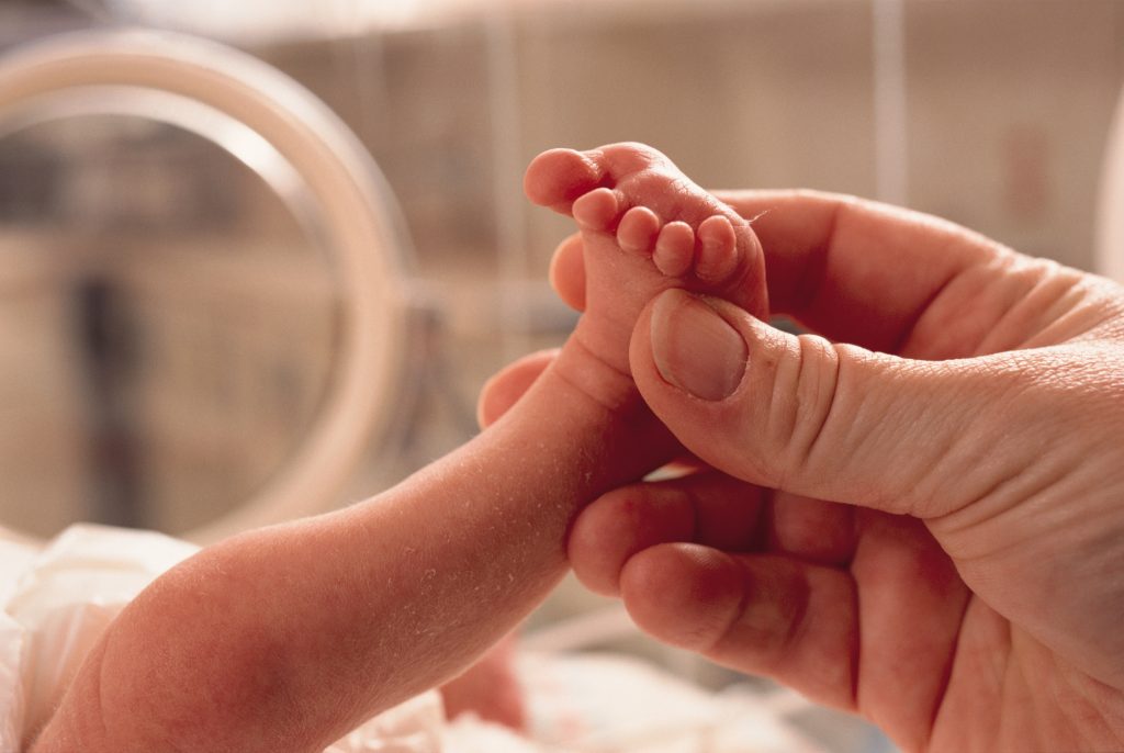 Une main tenant le pied d’un nouveau-né