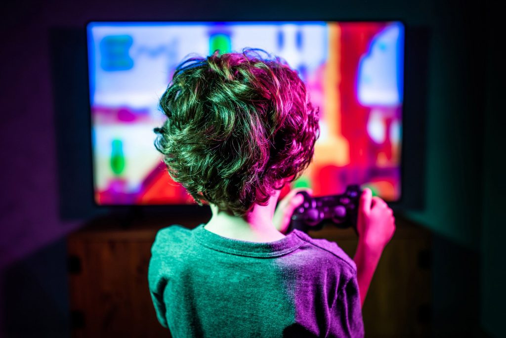 Un jeune garçon de la génération jouant aux jeux vidéo, comptant parmi ceux consacrant jusqu’à 4 heures de temps passé sur réseaux sociaux.