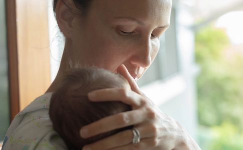 Une mère ayant fraichement accouché qui réfléchit au prénom de bébé pour son nouveau-né.
