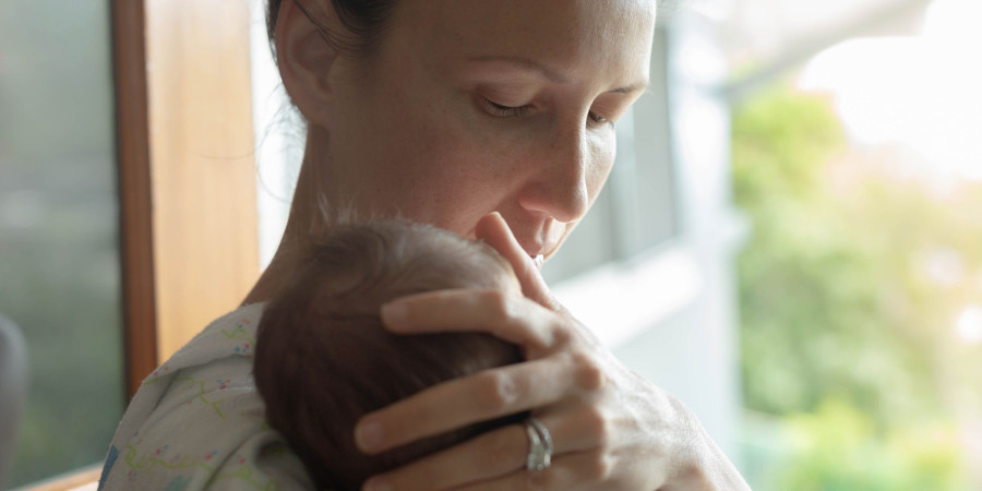 Une mère ayant fraichement accouché qui réfléchit au prénom de bébé pour son nouveau-né.