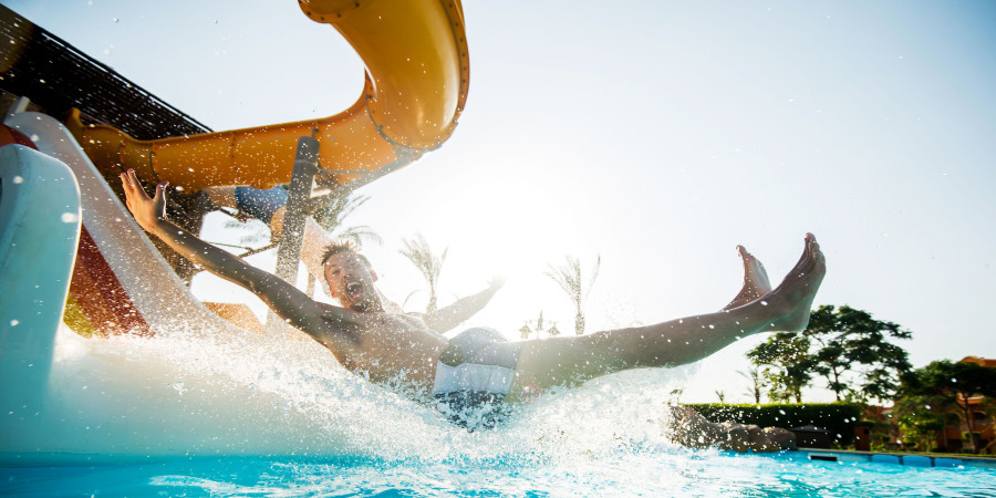 Un jeune homme glissant sur un toboggan aquatique, un concept que nombre de parcs d’attractions vont reprendre.