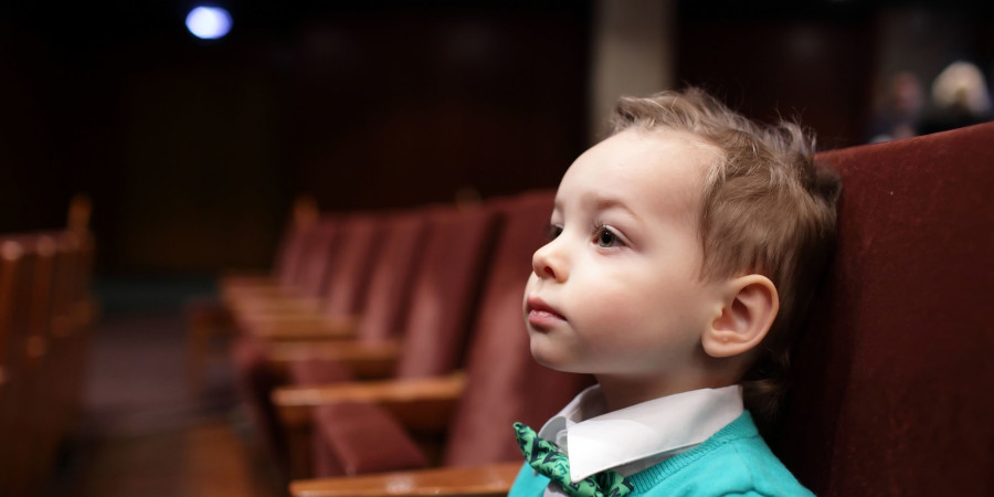 Aller à un concert fascine les tout-petits, comme l’illustre ce petit garçon assis dans les tribunes d’une salle de spectacle.