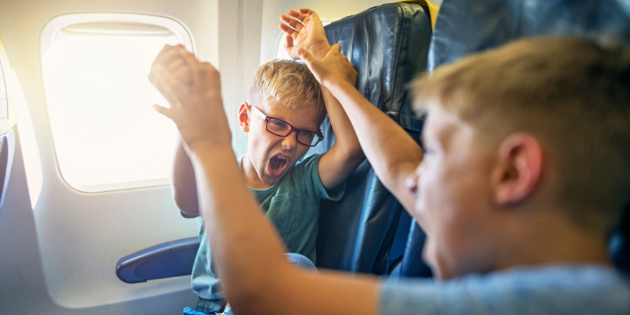 Deux garçons en train de se chamailler dans un avion, une des raisons justifiant la création d’une zone pour les voyageurs sans enfants.