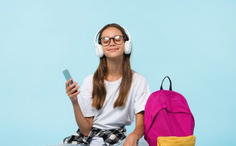 Une jeune adolescente en train d’écouter allègrement de la musique, n’ayant aucune conscience de l’inflation de la rentrée.