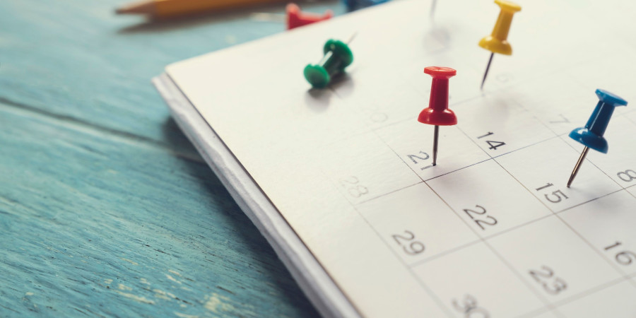Un calendrier où les dates de congés spéciaux sont marquées par des punaises colorées.