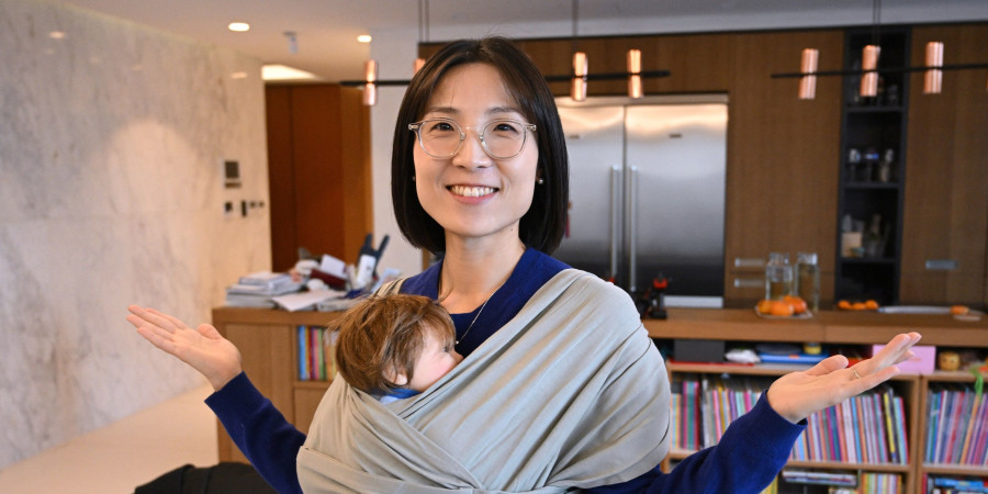 La fondatrice de Konny Baby avec un bébé dans un porte-bébé, une entreprise choyant ses salariés parents.