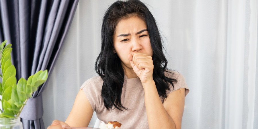 Une jeune femme en train de s’étouffer avec un aliment coincé dans la gorge.