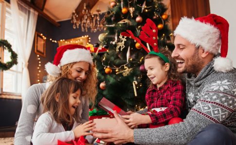 Une famille dans son salon ouvrant des présents et qui s’adonnera sûrement à la revente cadeaux Noël plus tard.