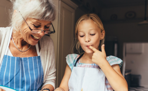 Une fillette et sa grand-mère en train de préparer des recettes familiales.