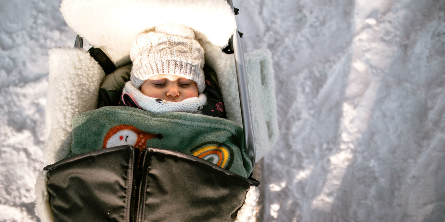 Un enfant dehors dans son landau, pratiquant la sieste nordique des bébés.