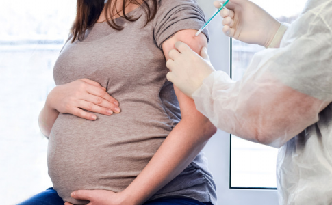 Une femme enceinte recevant une injection de vaccin, limitant ainsi le taux de mortalité maternelle aux États-Unis.