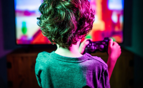 Un petit garçon, manette à la main, découvrant les bienfaits des jeux vidéo.