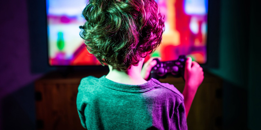 Un petit garçon, manette à la main, découvrant les bienfaits des jeux vidéo.