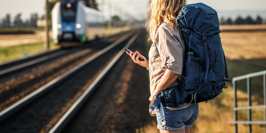 Une jeune fille avec son sac de randonnée, prête pour un voyage en train.