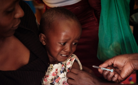 Une enfant avec sa mère en train de se faire vacciner contre la malaria ou paludisme.