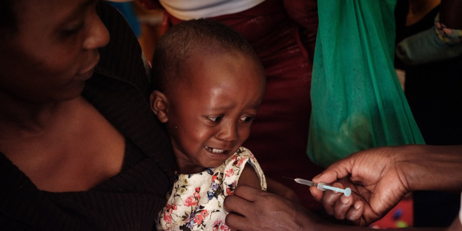 Une enfant avec sa mère en train de se faire vacciner contre la malaria ou paludisme.
