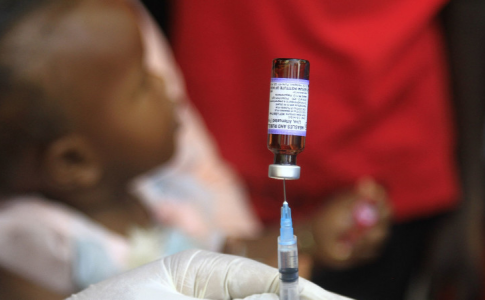 Une enfant attendant son injection de vaccin anti-rougeole, une parmi les vies sauvées grâce à la vaccination.