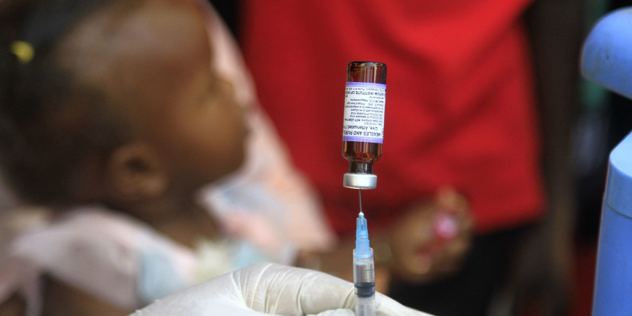Une enfant attendant son injection de vaccin anti-rougeole, une parmi les vies sauvées grâce à la vaccination.