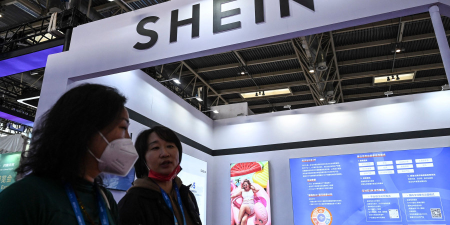 Deux Coréennes devant une boutique proposant des produits Shein pour enfants.