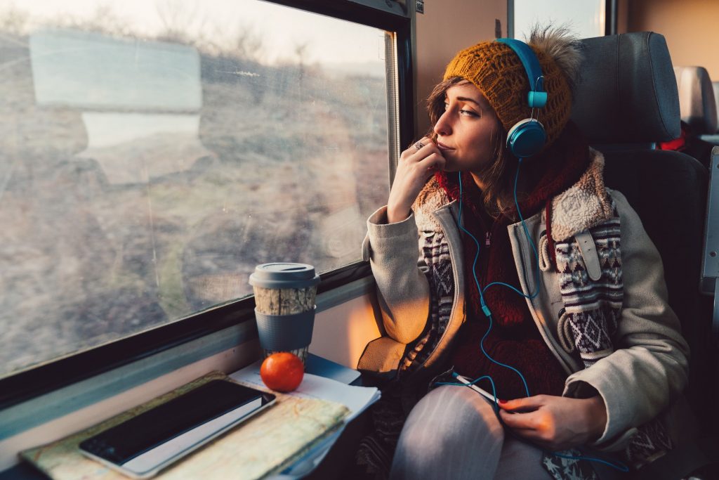 Une jeune femme dans le train portant un casque audio aux oreilles