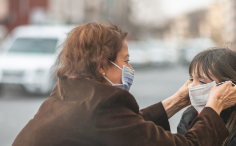 Une mère dotant sa fille d’un masque chirurgical afin de la protéger de la pollution aérienne.