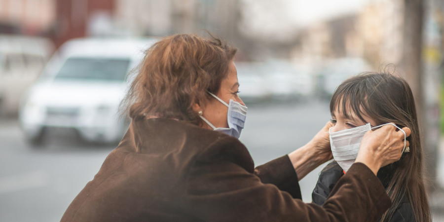 Une mère dotant sa fille d’un masque chirurgical afin de la protéger de la pollution aérienne.