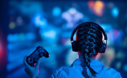 Une jeune fille concentrée joue un jeu vidéo sur son écran de télévision, immergée dans l'univers virtuel du jeu