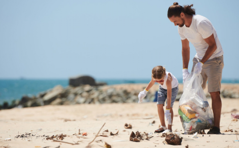 Conscients de l’impact écologique des déchets en vacances, un père et sa fille nettoient une plage infestée d’ordures.