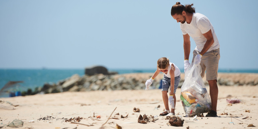 Conscients de l’impact écologique des déchets en vacances, un père et sa fille nettoient une plage infestée d’ordures.