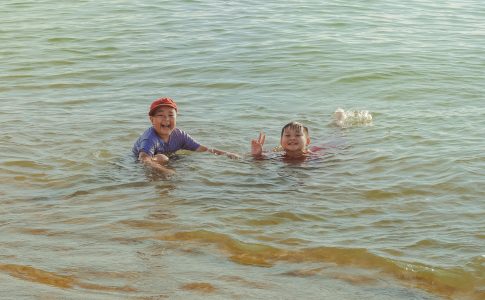 Deux jeunes enfants profitant d’une baignade dans un lac dont la qualité d’eau est vérifiée.