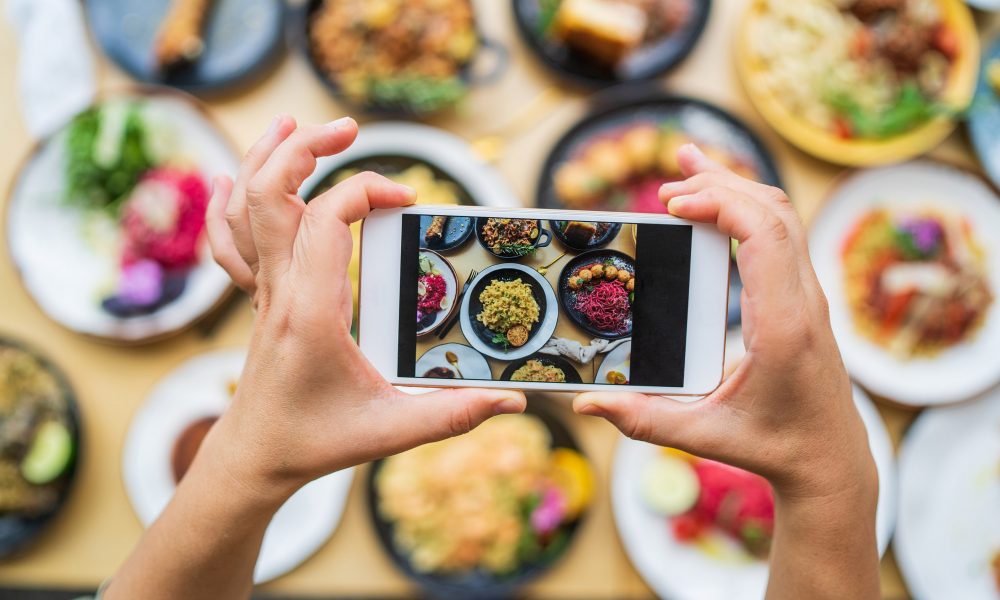 Mains personne prenant une photo de nourriture avec son smartphone