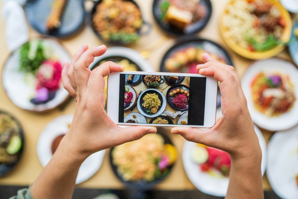 Mains personne prenant une photo de nourriture avec son smartphone