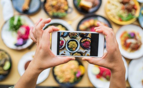 Mains personne prenant une photo de nourriture avec son smartphone