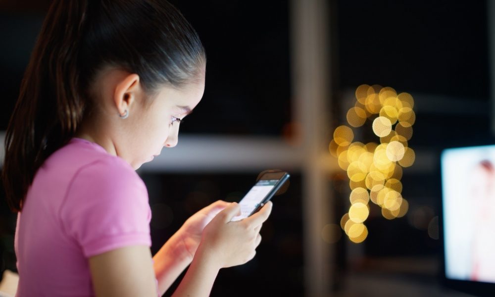 Une jeune fille jouant a un smartphone