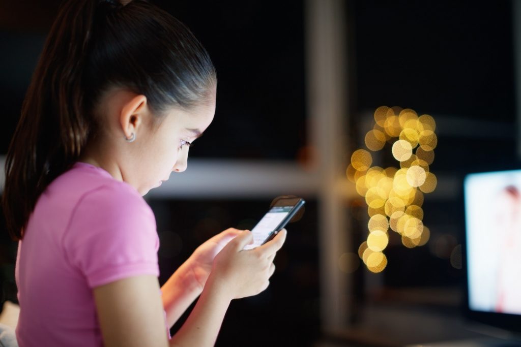 Une jeune fille jouant a un smartphone