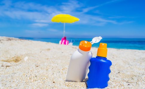 Deux flacons de creme solaire dans le sable sur la plage