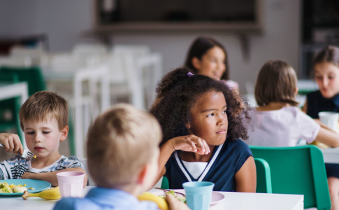 Des enfants en train de déjeuner dans une cantine scolaire.