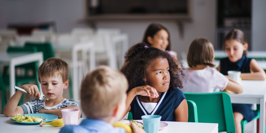 Des enfants en train de déjeuner dans une cantine scolaire.