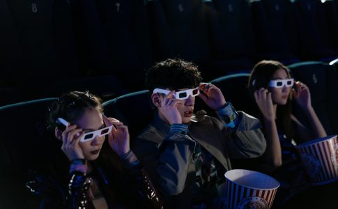 Trois jeunes au cinema portant des lunettes 3D