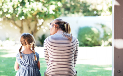 Une mère avec sa fille assises dans un jardin, en train de discuter.