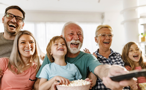 Une famille réunie dans leur salon, en train de regarder un film à la télévision.