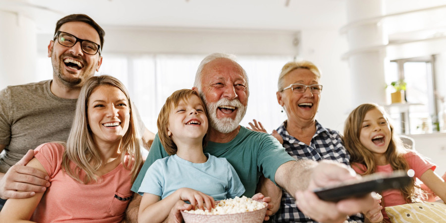 Une famille réunie dans leur salon, en train de regarder un film à la télévision.