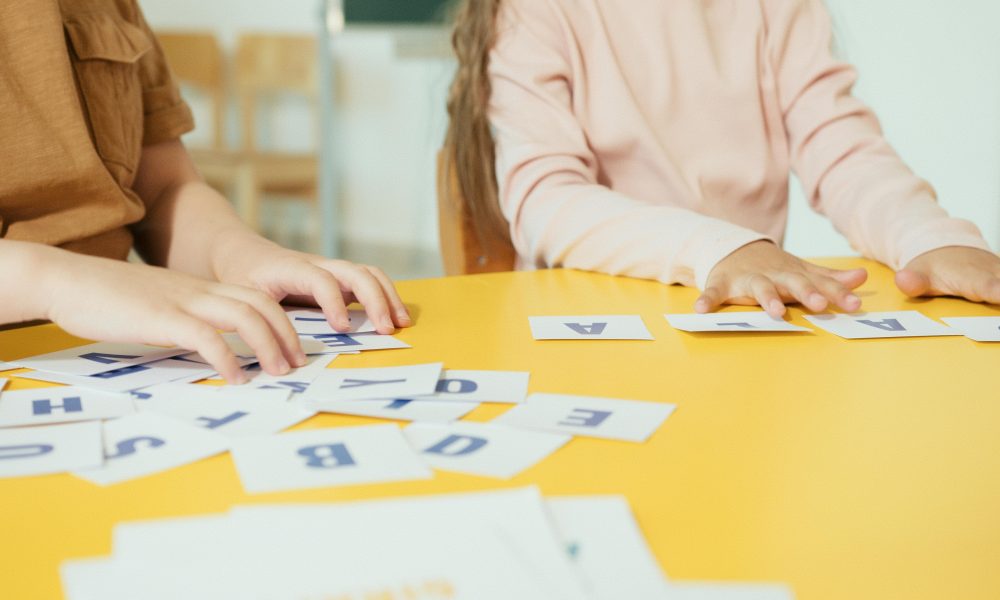 Des élèves allophones en train de former des mots français avec des carrés de lettres.