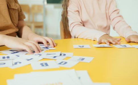 Des élèves allophones en train de former des mots français avec des carrés de lettres.