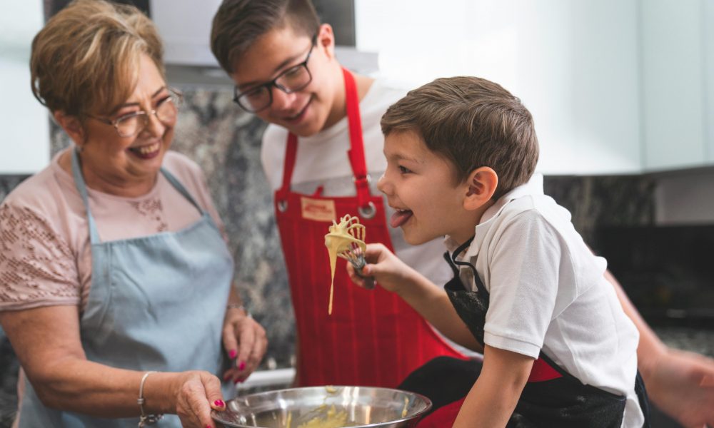 Un jeune garçon tenant un fouet lors d'un atelier cuisine mis en place par la Semaine du Goût 2024.