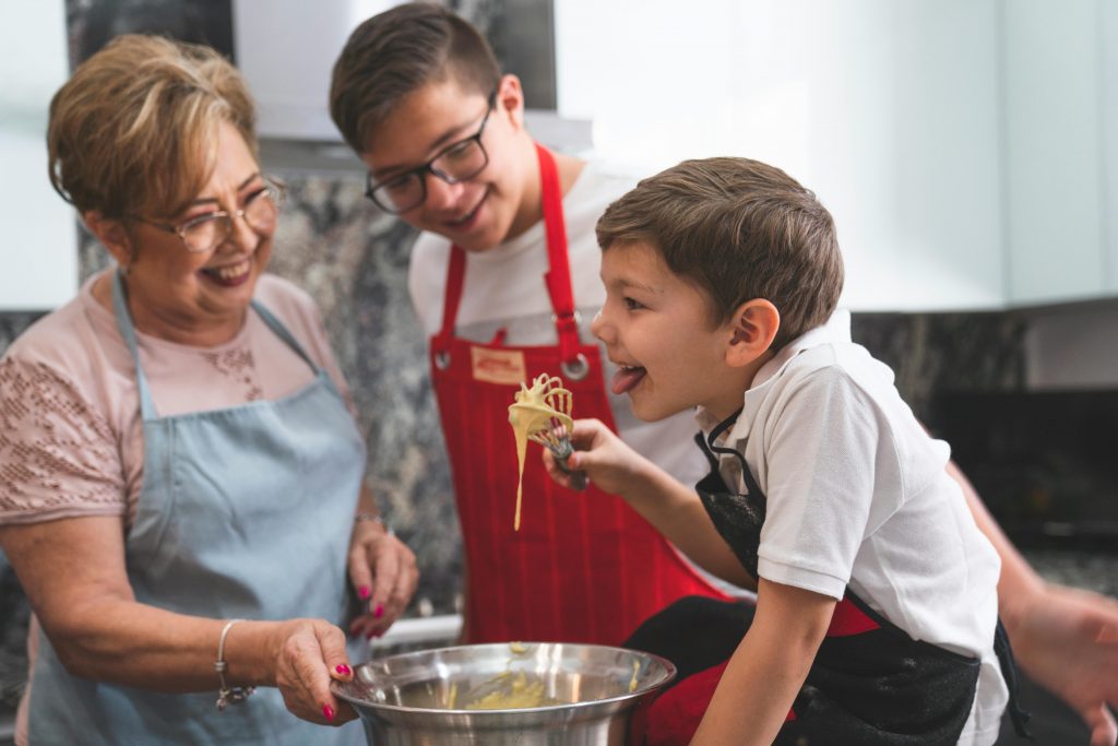 Un jeune garçon tenant un fouet lors d'un atelier cuisine mis en place par la Semaine du Goût 2024.